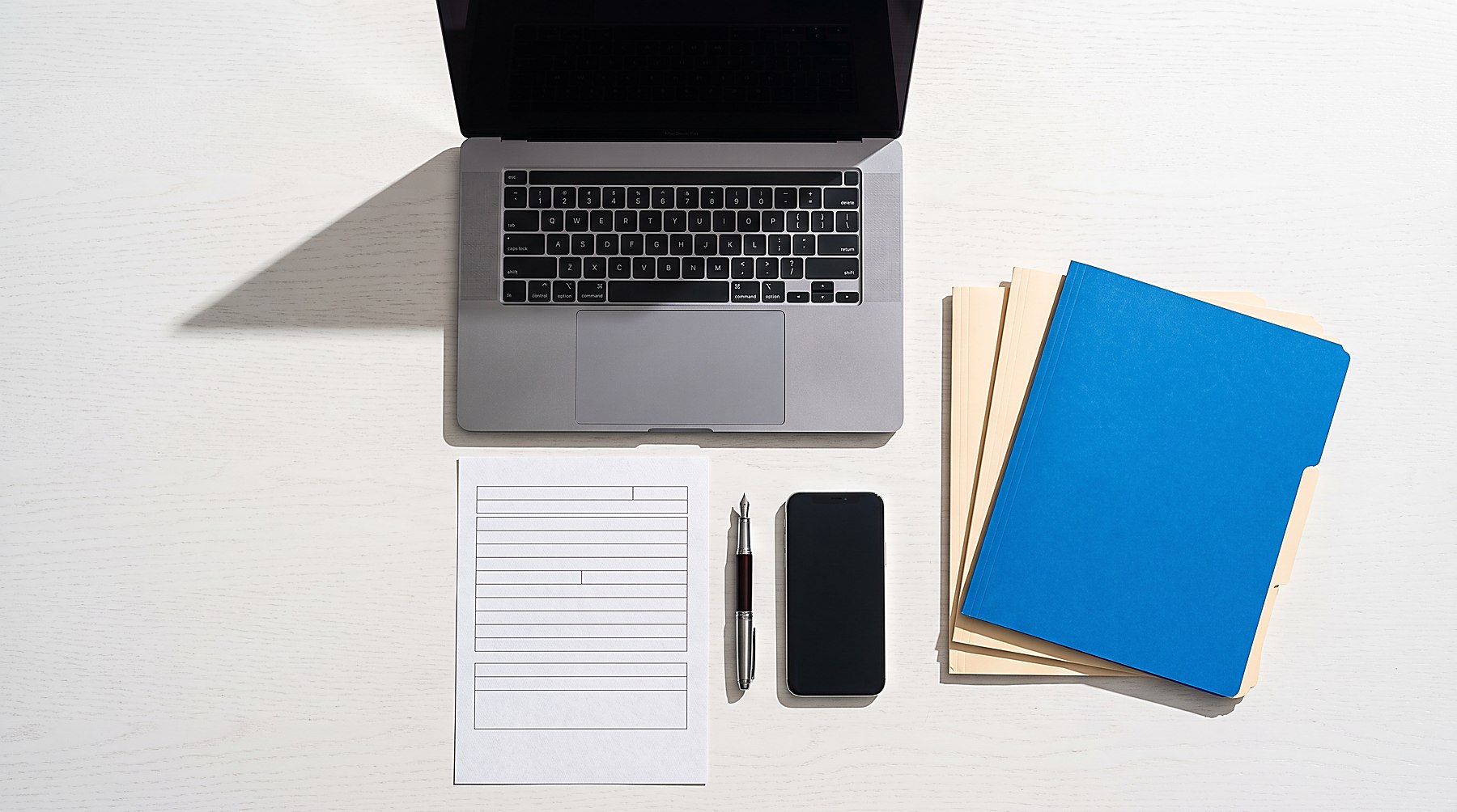 Arbeitsplatz mit Unterlagen und Laptop